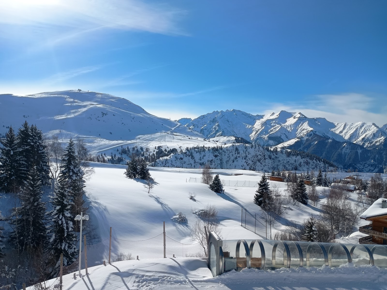 A high rocky glacier peak above Alpe d Huez with skiers on the snow