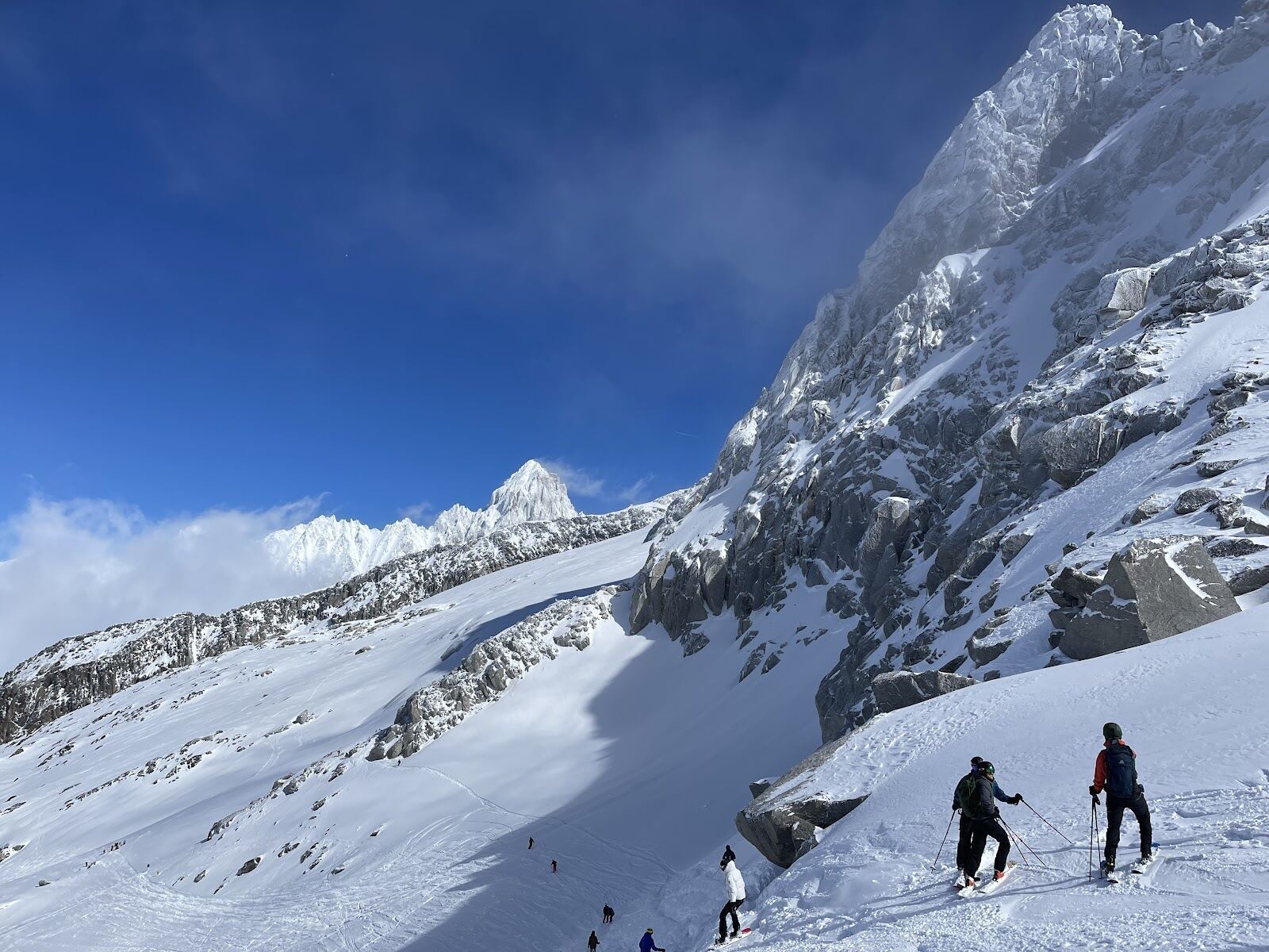 Skiers descending a steep snowy face above the Chamonix Valley