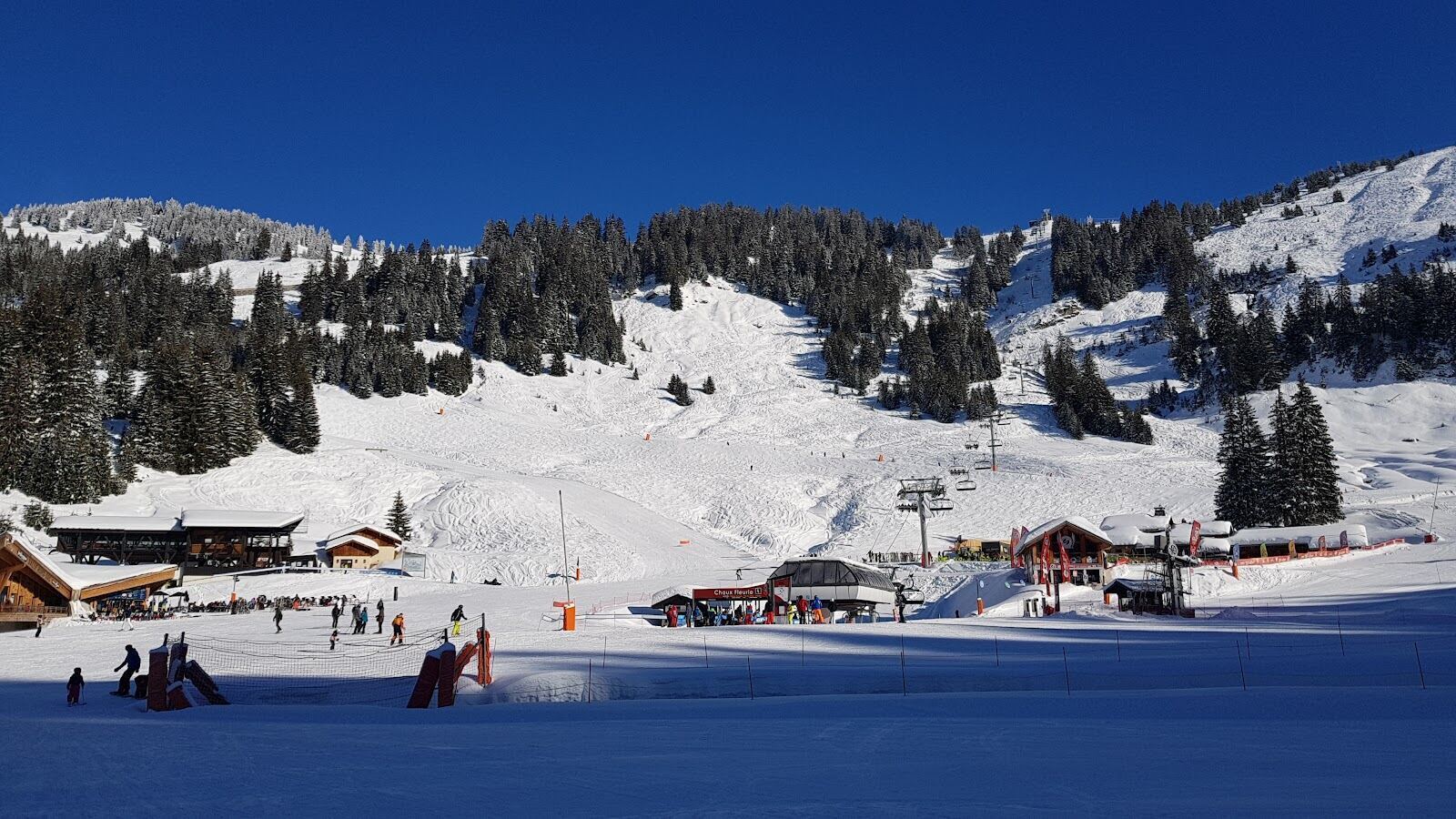 Chairlift rising over snow covered pine trees in the Portes du Soleil