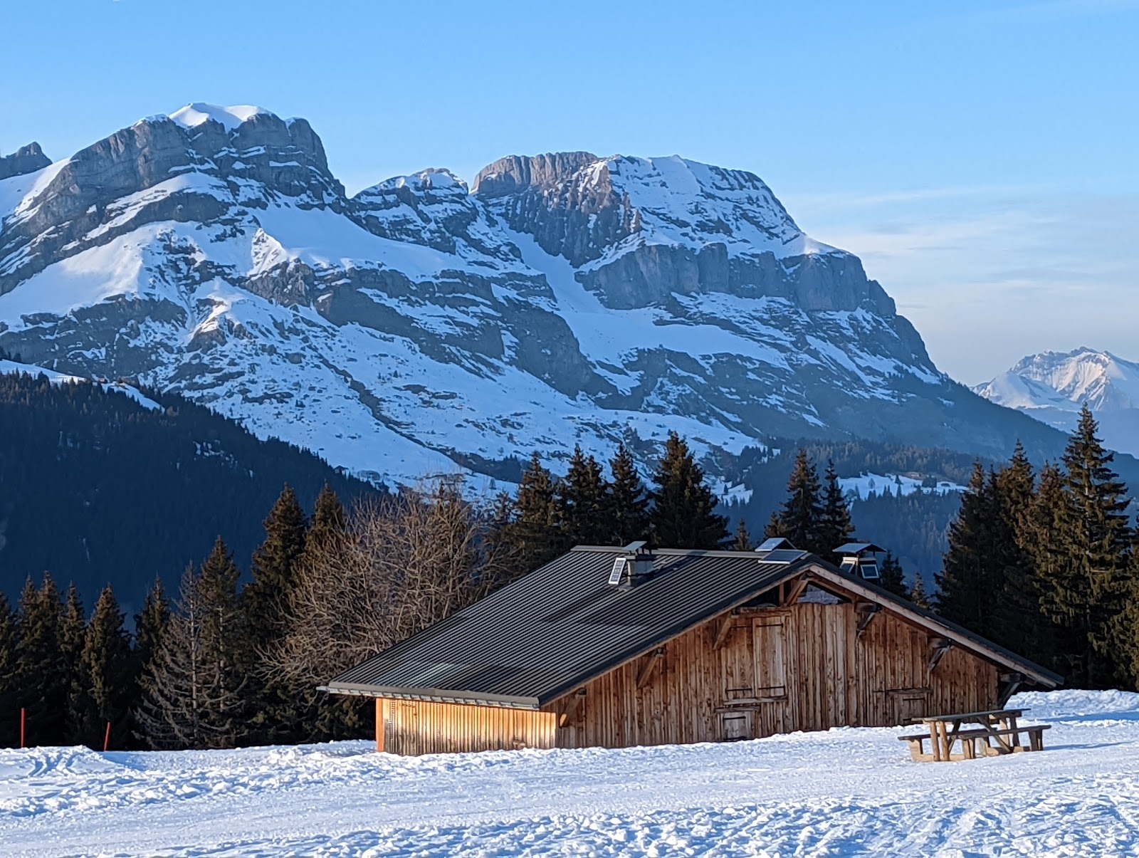 Snow covered chalets and the church of Combloux in winter light