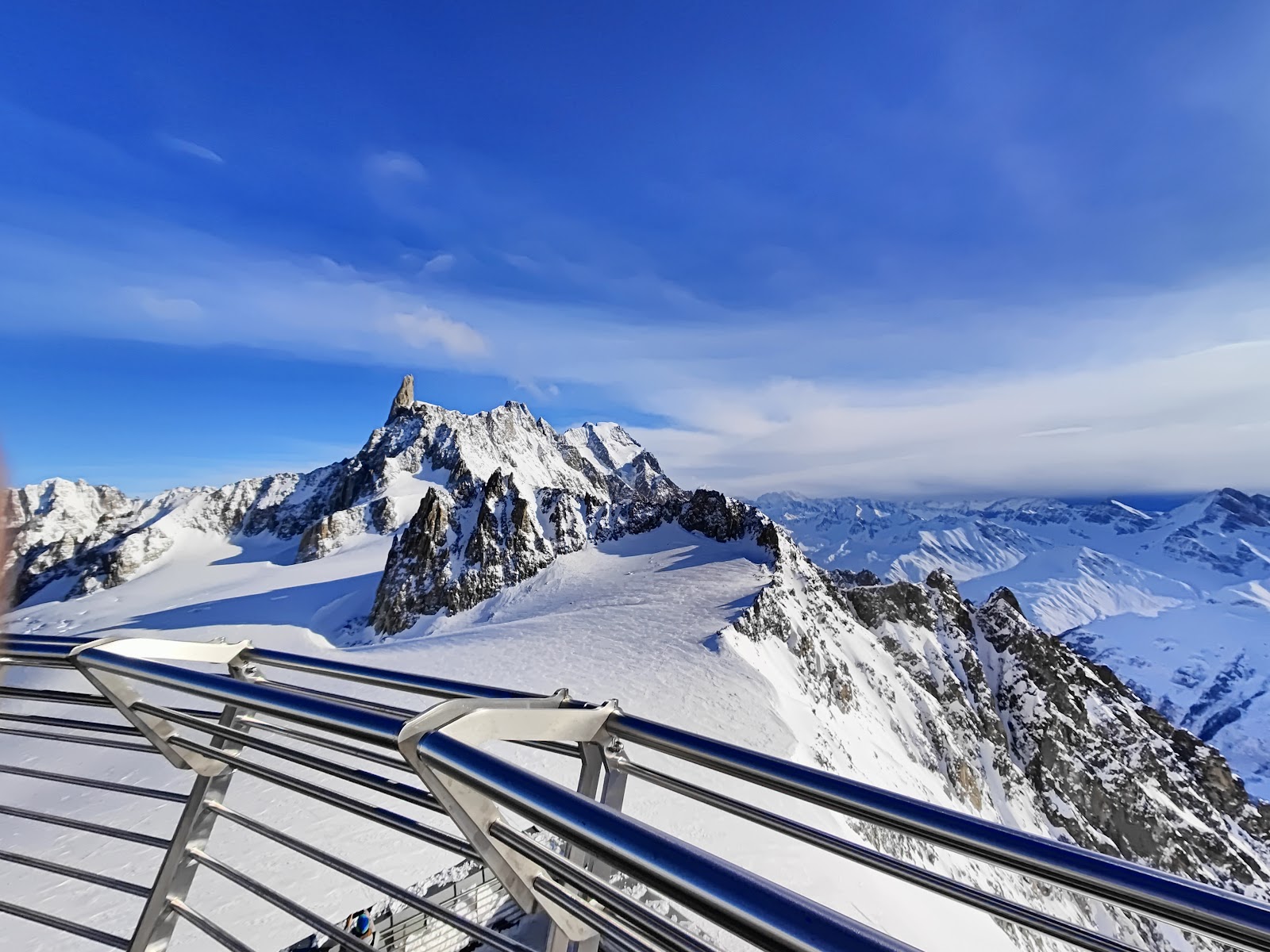 A busy mountain restaurant terrace above Courmayeur with skiers eating in the sun