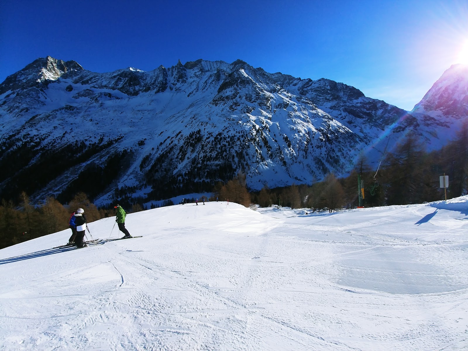 Skiers on a quiet well groomed run in the Evolene ski area