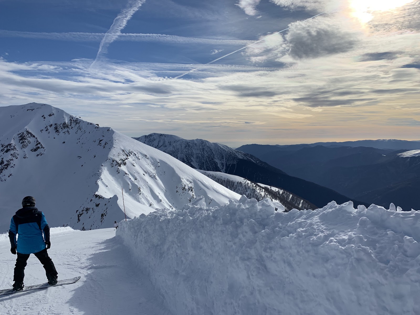 Skiers on a wide blue run under blue sky near the Mediterranean