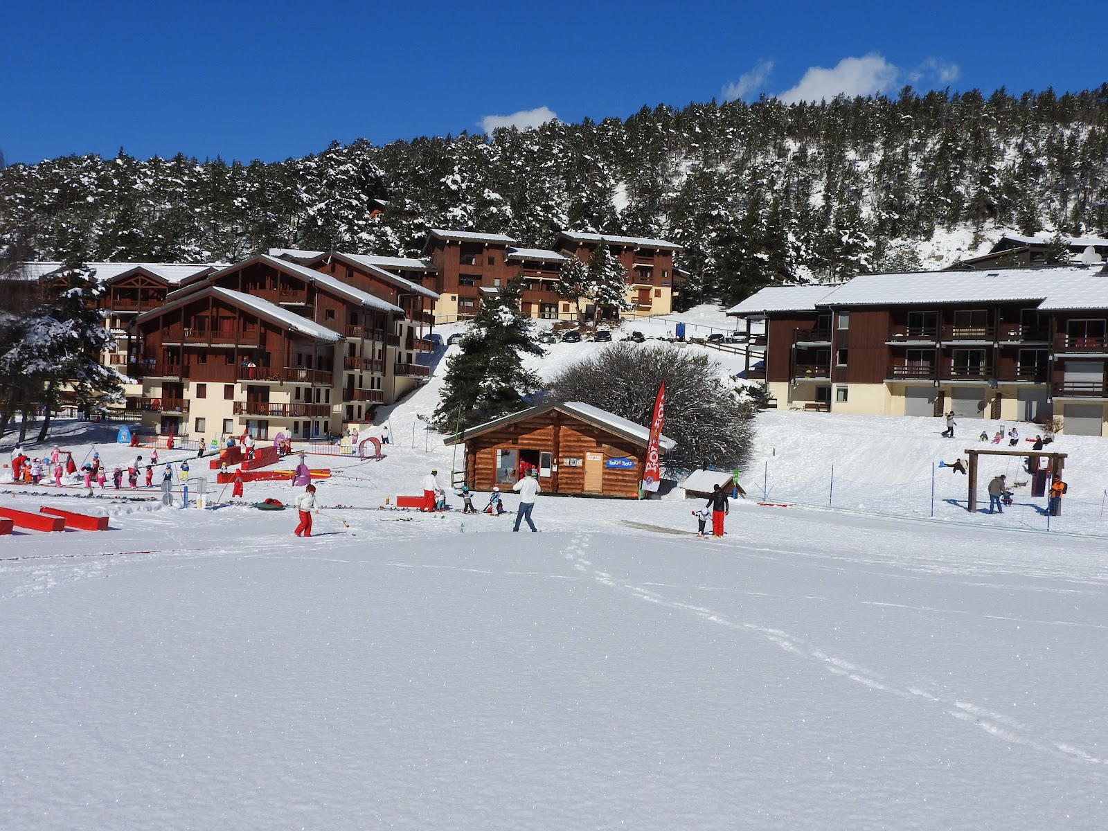 Skiers on a sunny groomed run above La Norma in the Maurienne
