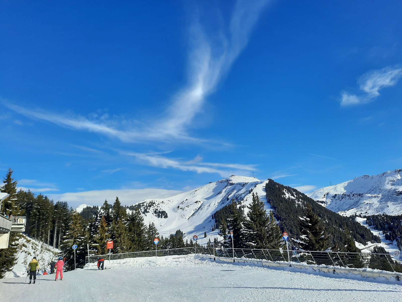 Skiers on a wide blue run linking toward Flaine