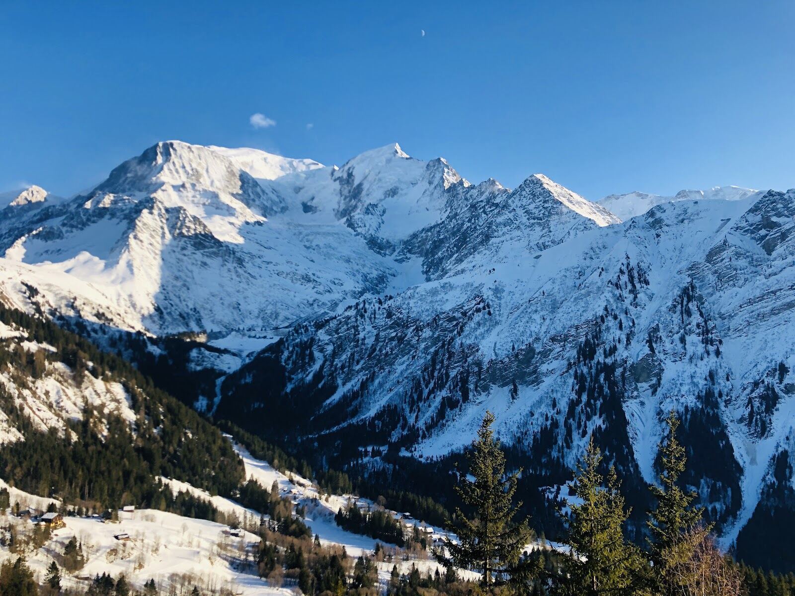 Skiers on a wide forest run at Les Houches with Mont Blanc views