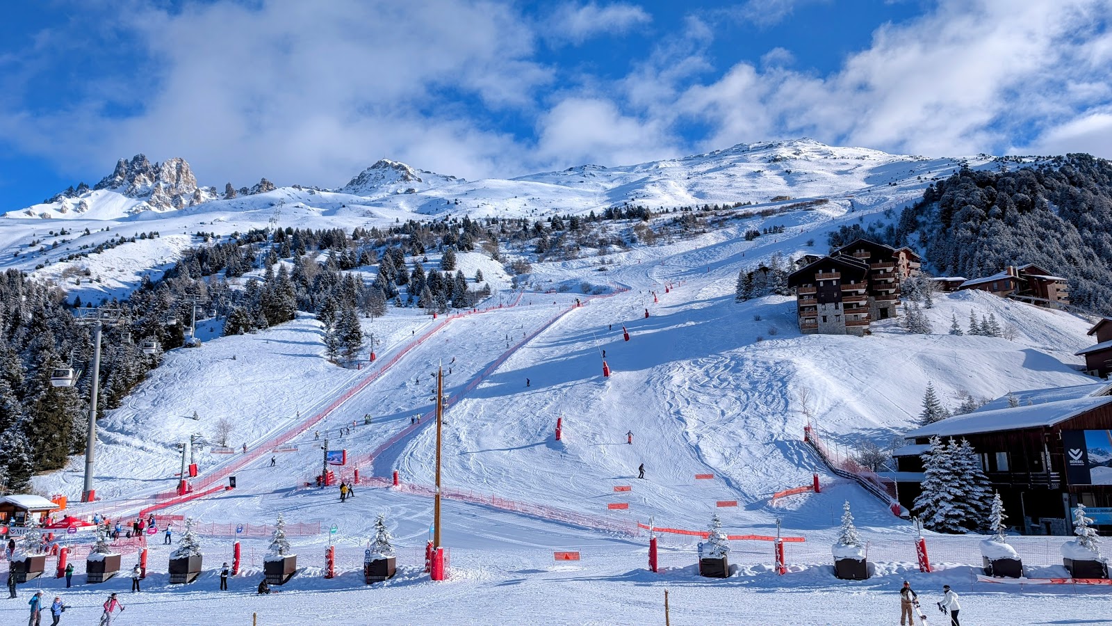 A busy sunny mountain terrace with skiers enjoying apres ski