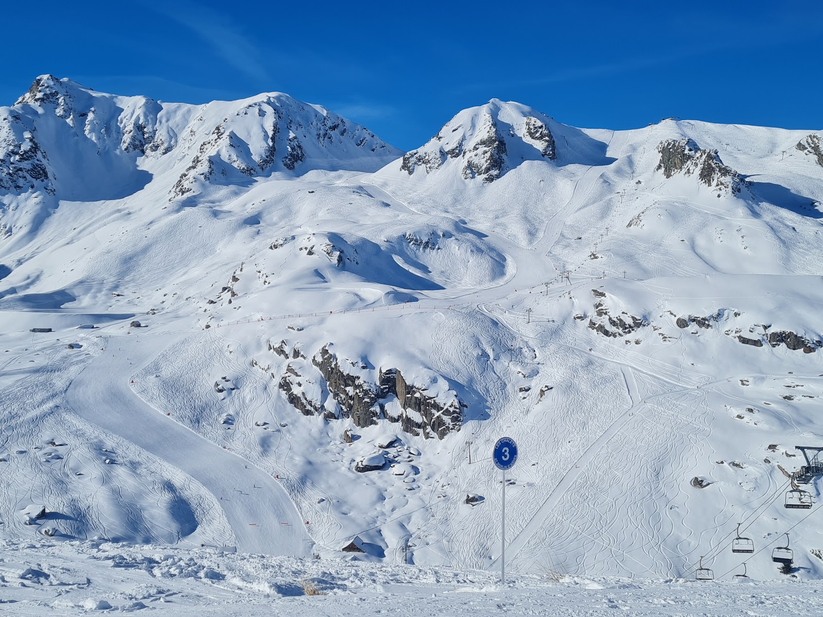 Skiers crossing the linked Les Sybelles ski area on a clear day