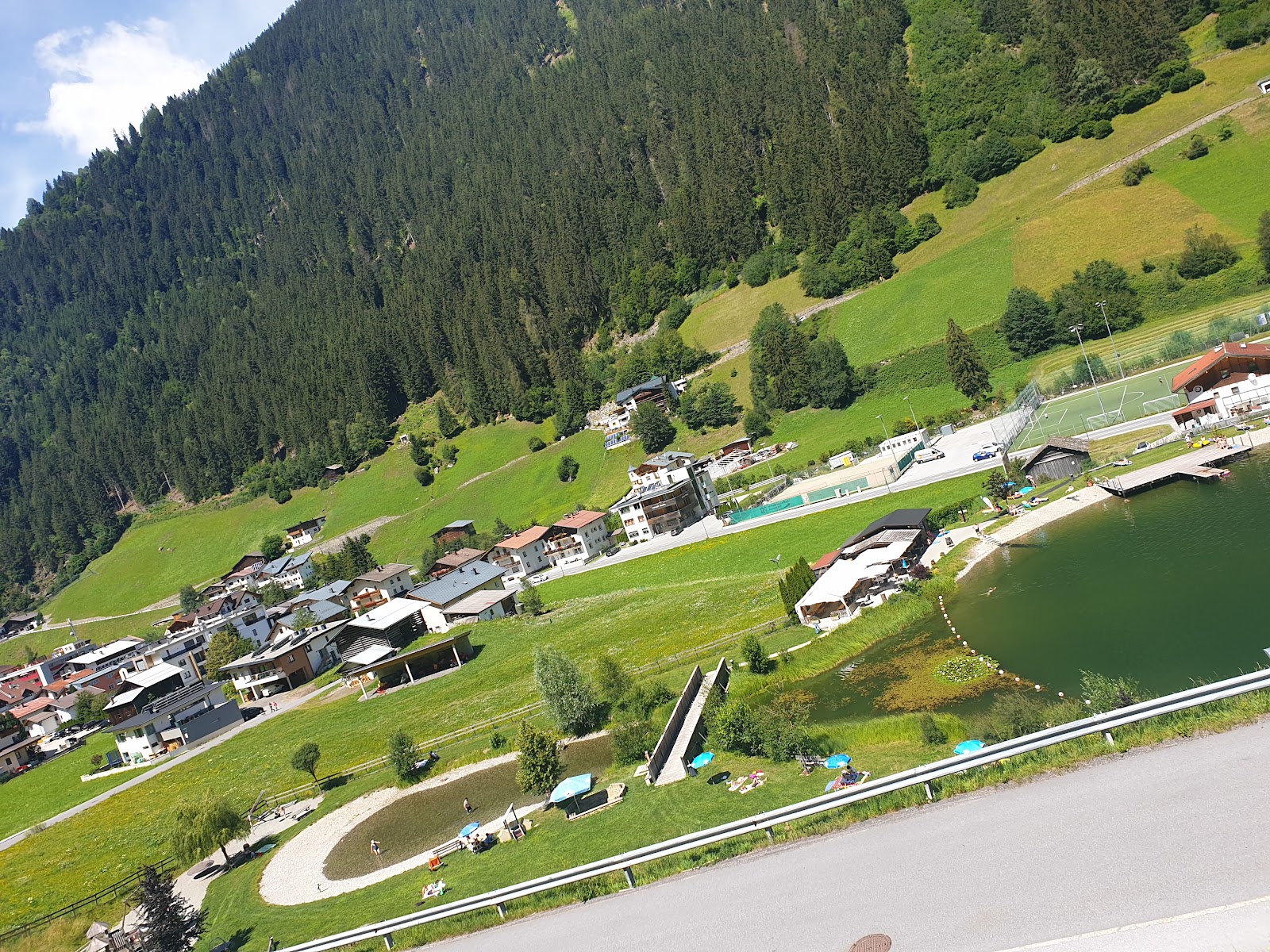 Red pistes winding through trees above the village of See in Tyrol