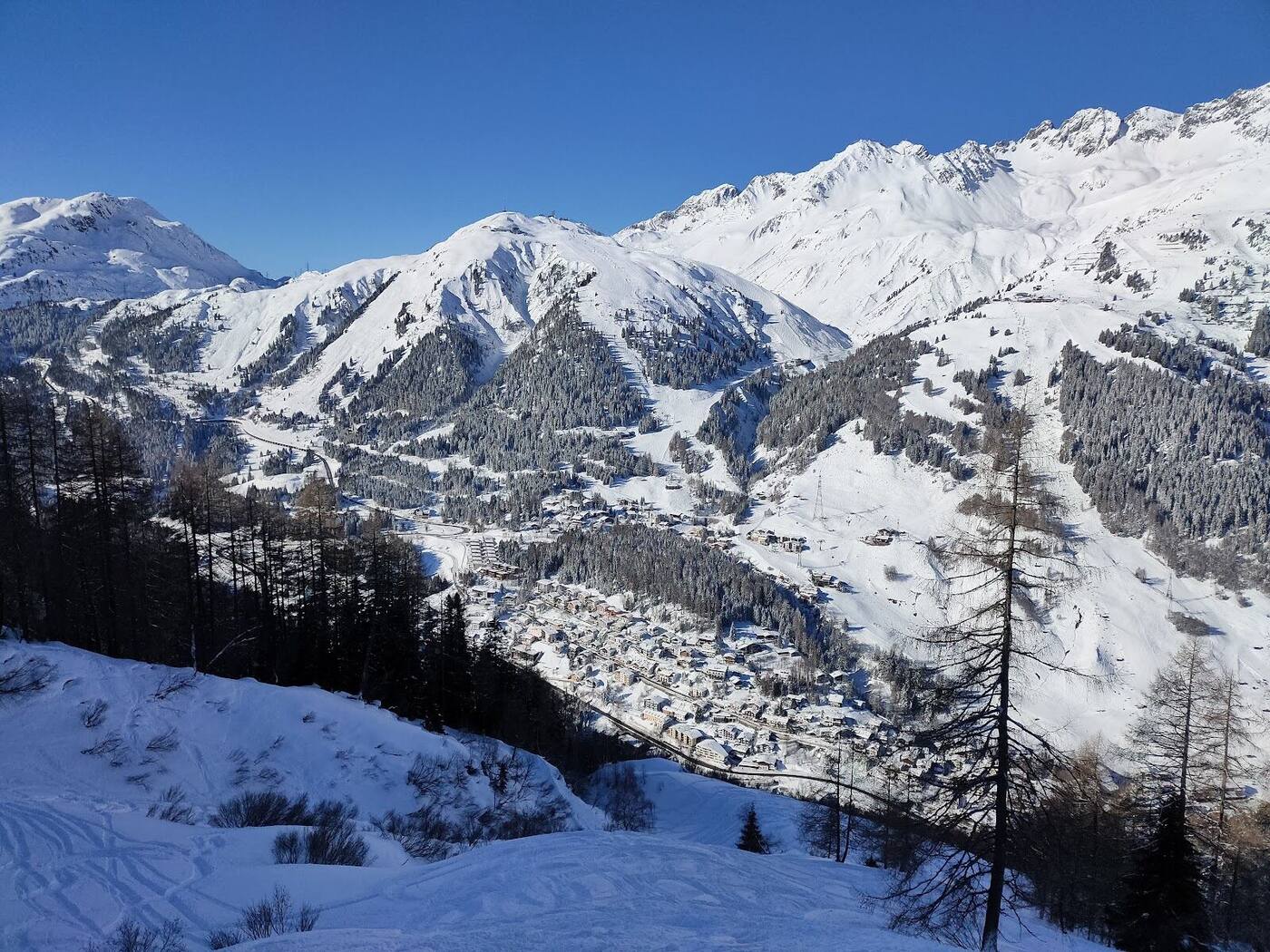 Crowds enjoying apres ski on a sunny slope side terrace at St Anton