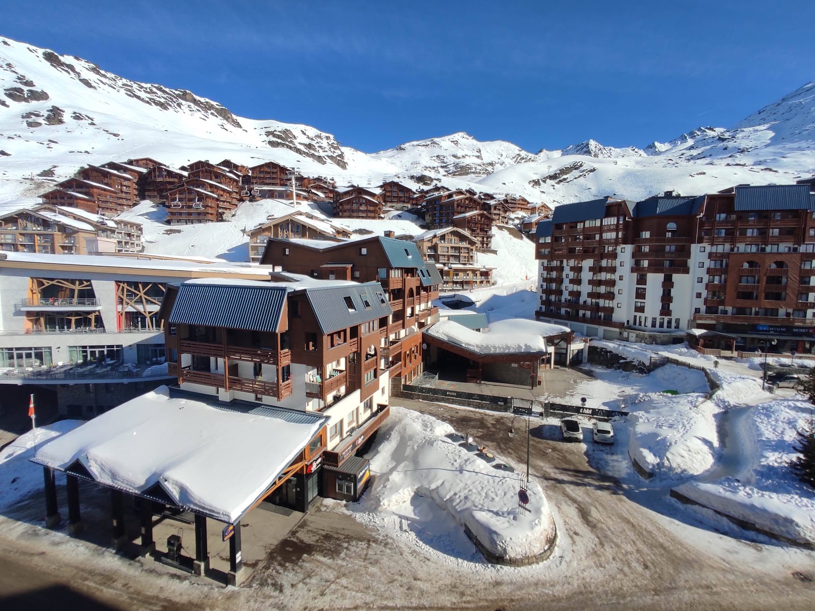 A busy mountain terrace with skiers enjoying apres ski drinks in the sun