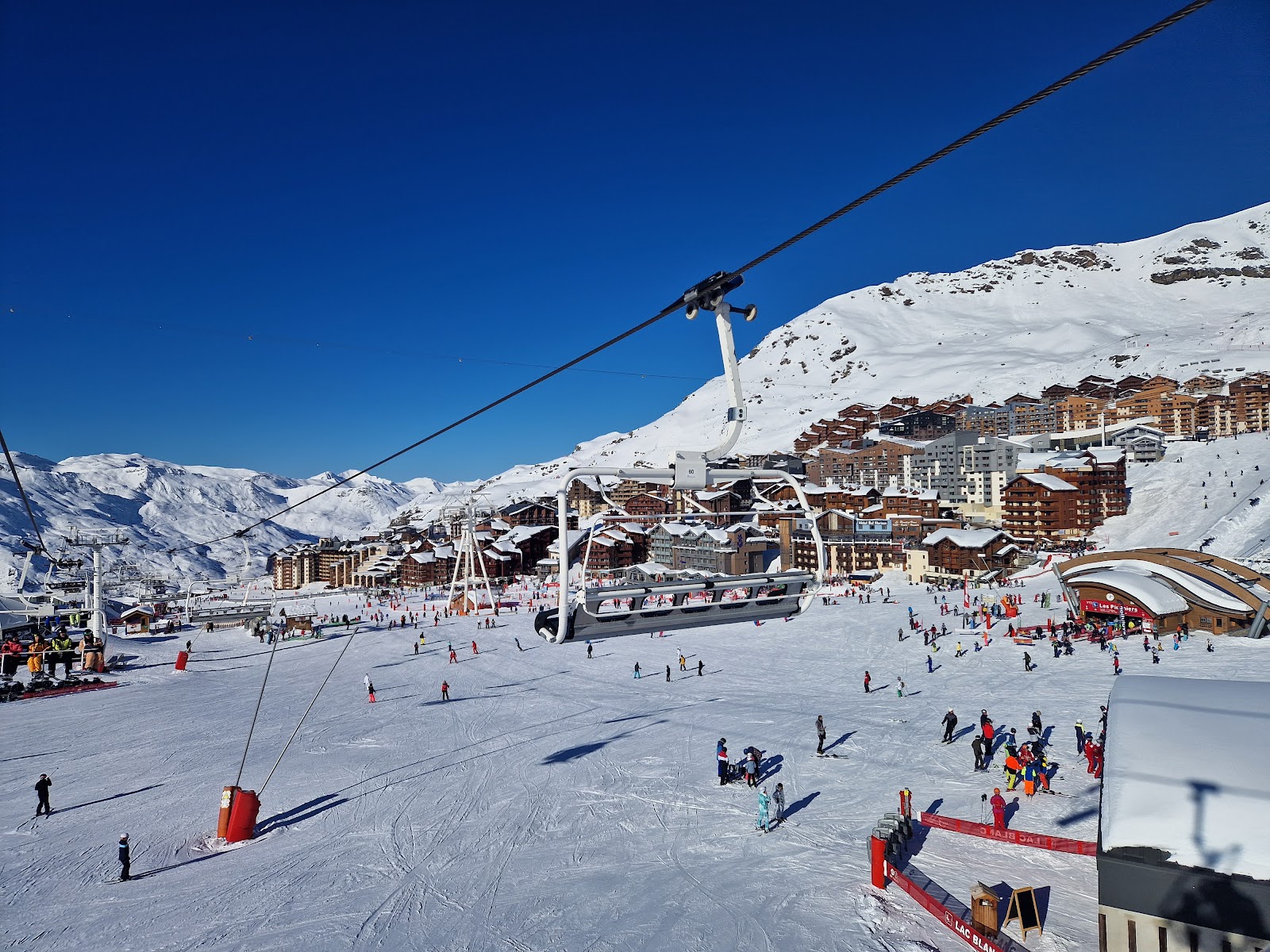 A snowy high altitude French alpine resort base with ski apartments and lifts