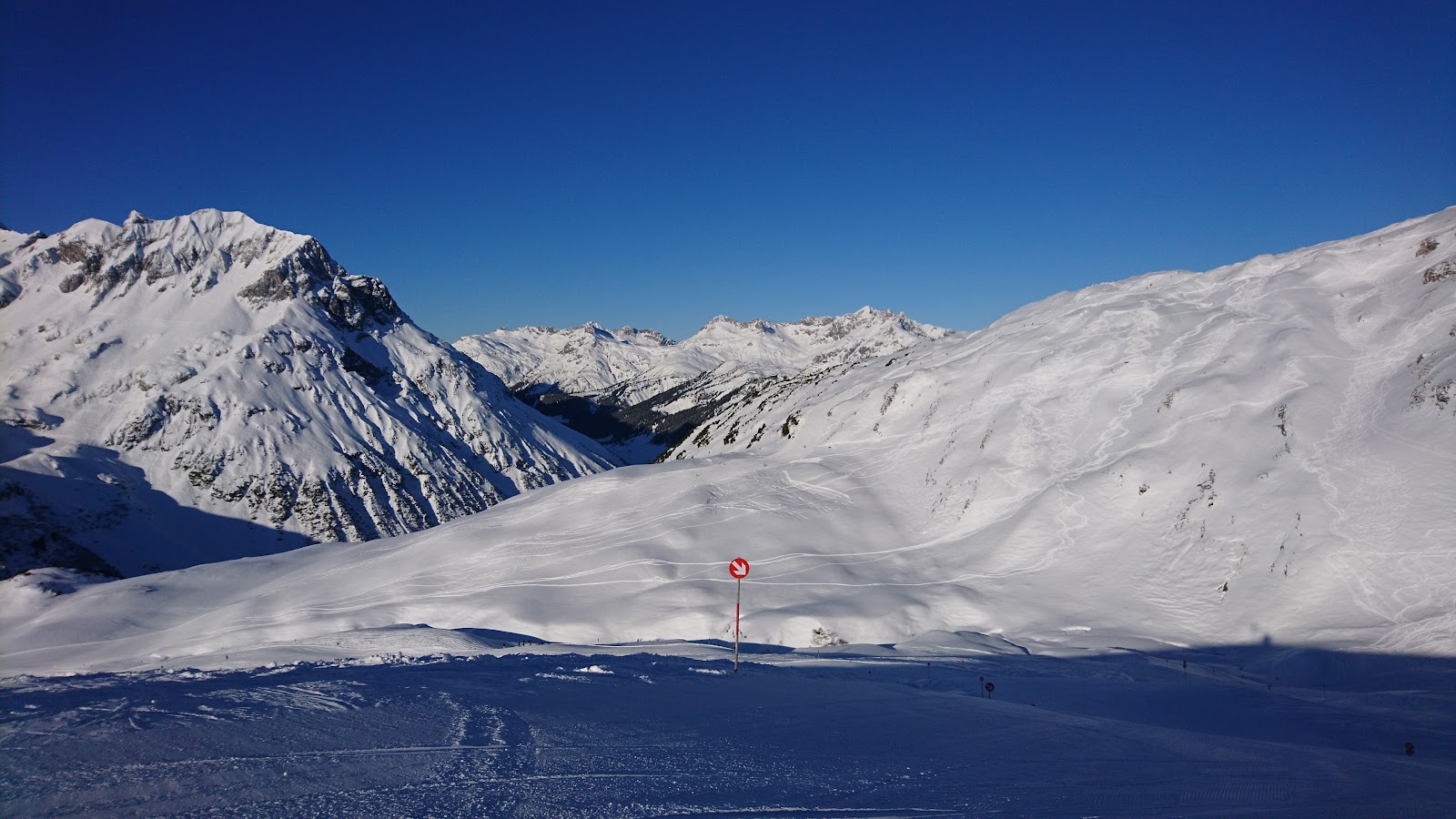 Snow covered high alpine village of Zurs with hotels below treeless ski slopes