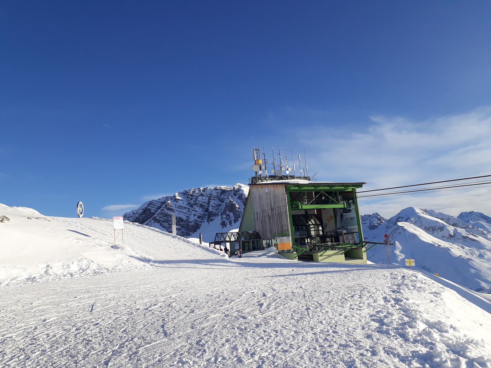 A wide treeless blue piste curving down toward the hotels of Zurs
