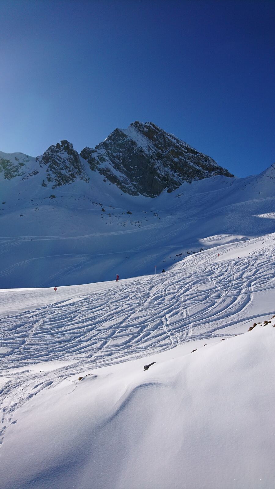 Skiers on a chairlift over sunny Arlberg slopes near Zurs